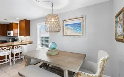 a kitchen and dining room with a wooden table and chairs at Aqua Bella by Oversee 30A in Santa Rosa Beach