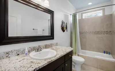 a bathroom with a sink and a toilet and a mirror at Beach Bike Bungaleaux by Oversee 30A in Seacrest