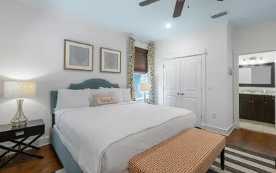a bedroom with a large white bed and a bench at Beach Bike Bungaleaux by Oversee 30A in Seacrest