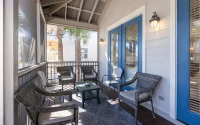 a front porch with chairs and a table at Beach Dreamer by Oversee 30A in Seacrest
