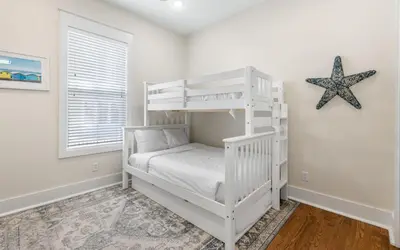 a white bunk bed in a white room with a starfish at Beach Dreamer by Oversee 30A in Seacrest