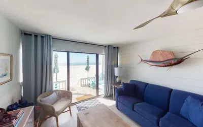 a living room with a blue couch and a window at Beach Pleeze by Oversee 30A in Panama City Beach