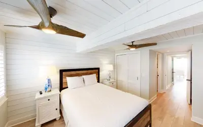 a white bedroom with a bed and a ceiling at Beach Pleeze by Oversee 30A in Panama City Beach