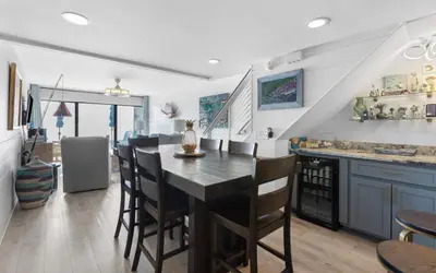 a kitchen and dining room with a table and chairs at Beach Pleeze by Oversee 30A in Panama City Beach