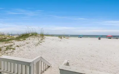 a sandy beach with umbrellas and the ocean at Beachfront Oasis by Oversee 30A in Panama City Beach