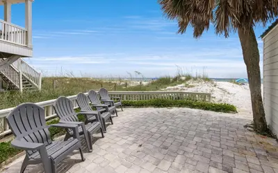 a row of chairs sitting next to the beach at Beachfront Oasis by Oversee 30A in Panama City Beach