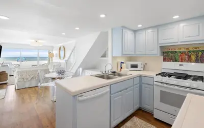 a kitchen with white cabinets and a view of the ocean at Beachfront Oasis by Oversee 30A in Panama City Beach