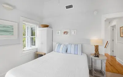 a white bedroom with a bed and a table at Bimini by Oversee 30A in Carillon Beach