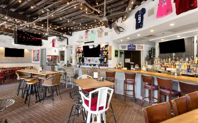 a restaurant with tables and chairs and a bar at Bimini by Oversee 30A in Carillon Beach