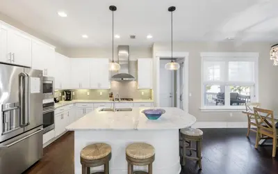 a kitchen with white cabinets and a counter with stools at Flatwoods 134 by Oversee 30A in Santa Rosa Beach