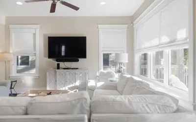 a living room with white furniture and a flat screen tv at Flatwoods 134 by Oversee 30A in Santa Rosa Beach