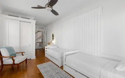a white living room with a couch and a ceiling fan at Peaceful Easy Feeling by Oversee 30A in Carillon Beach