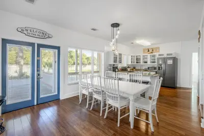 a kitchen and dining room with a white table and chairs at Coral Reef by Oversee 30A in Santa Rosa Beach