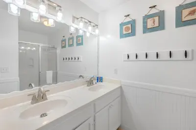 a white bathroom with two sinks and a mirror at Coral Reef by Oversee 30A in Santa Rosa Beach