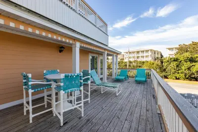 a deck with blue chairs and a table at Coral Reef by Oversee 30A in Santa Rosa Beach
