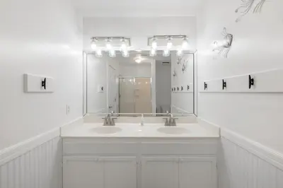 a white bathroom with two sinks and a mirror at Coral Reef by Oversee 30A in Santa Rosa Beach