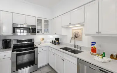 a white kitchen with white cabinets and a sink at Seagrove Villa B202 by Oversee 30A in Santa Rosa Beach