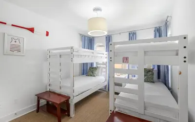 a room with two bunk beds and a table at Seagrove Villa B202 by Oversee 30A in Santa Rosa Beach