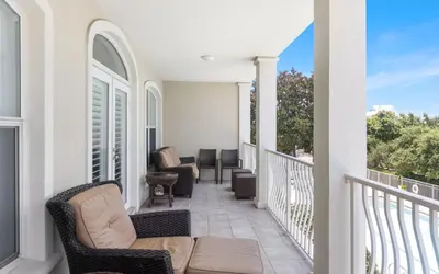 a balcony with chairs and tables on a house at Seagrove Villa B202 by Oversee 30A in Santa Rosa Beach
