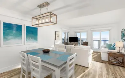 a dining room and living room with a table and chairs at Top Shellf by Oversee 30A in Carillon Beach