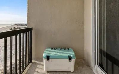 a cooler sitting on a balcony next to a window at Top Shellf by Oversee 30A in Carillon Beach