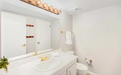 a white bathroom with a sink and a mirror at Ocean Breezes by Oversee 30A in Carillon Beach
