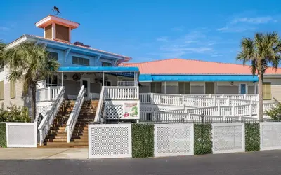 a house with a white fence and palm trees at Ocean Breezes by Oversee 30A in Carillon Beach