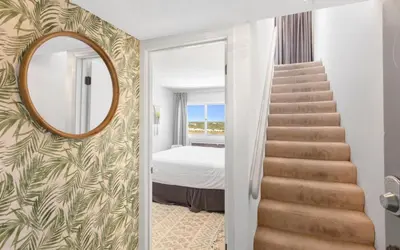 a stairway leading to a bedroom with a mirror at Ocean Breezes by Oversee 30A in Carillon Beach
