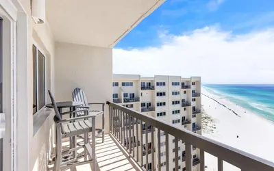 a balcony with a table and chairs and the beach at Ocean Breezes by Oversee 30A in Carillon Beach