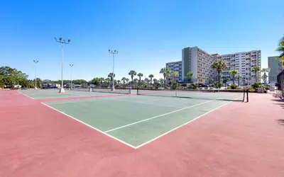 a tennis court in a city with buildings at Drift on Inn by Oversee 30A in Carillon Beach
