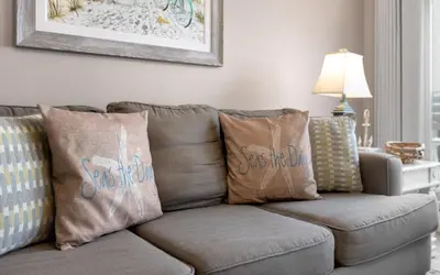 a couch with pillows on it in a living room at Drift on Inn by Oversee 30A in Carillon Beach