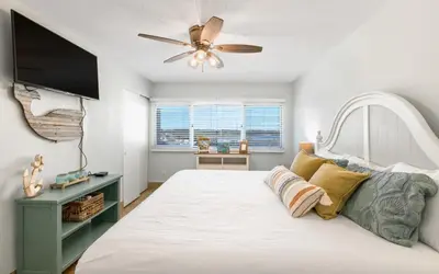 a bedroom with a large bed with a ceiling fan at Drift on Inn by Oversee 30A in Carillon Beach