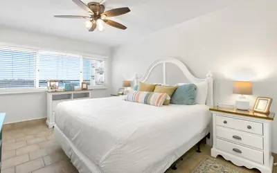 a bedroom with a white bed and a ceiling fan at Drift on Inn by Oversee 30A in Carillon Beach