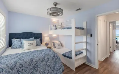 a bedroom with a bed and a book shelf at The Little Round Up by Oversee 30A in Panama City Beach
