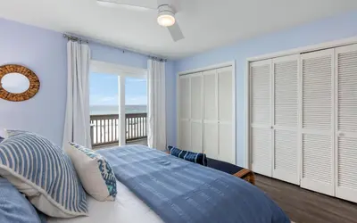 a bedroom with a bed with a view of the ocean at The Little Round Up by Oversee 30A in Panama City Beach