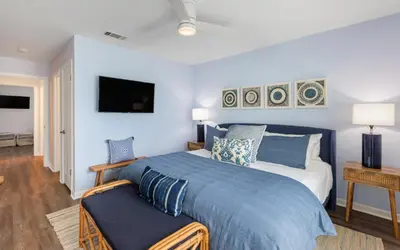 a bedroom with a king sized bed and a tv at The Little Round Up by Oversee 30A in Panama City Beach