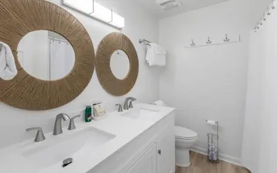 a bathroom with a sink and a mirror on the wall at The Little Round Up by Oversee 30A in Panama City Beach