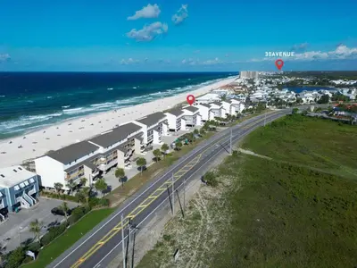 an aerial view of a beach with a road and buildings at The Little Round Up by Oversee 30A in Panama City Beach