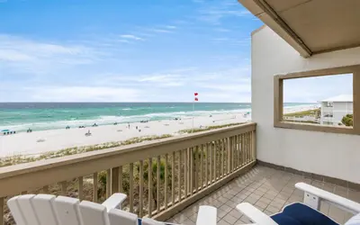 a balcony with chairs and a view of the beach at The Little Round Up by Oversee 30A in Panama City Beach