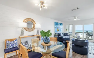 a living room with a glass table and chairs at The Little Round Up by Oversee 30A in Panama City Beach