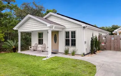 a white shed with a bench in a yard at Point Three by Oversee 30A in Panama City Beach