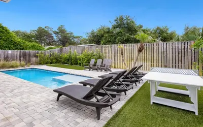 a patio with chairs and a table and a pool at Point Three by Oversee 30A in Panama City Beach