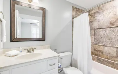 a bathroom with a sink and a toilet and a mirror at Point Three by Oversee 30A in Panama City Beach