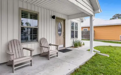 two chairs sitting on the front porch of a house at Point Three by Oversee 30A in Panama City Beach