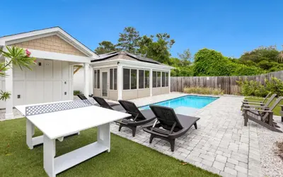 a backyard with a white table and chairs and a pool at Point Three by Oversee 30A in Panama City Beach