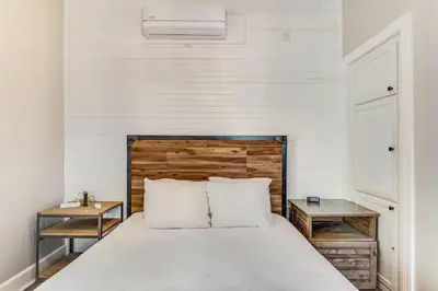 a bedroom with a bed with a wooden headboard and two tables at Village of South Walton B248 by Oversee 30A in Inlet Beach