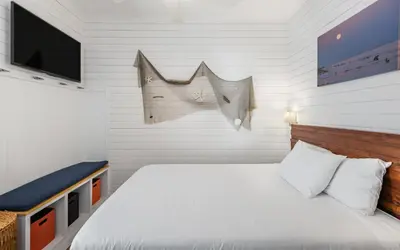 a small bedroom with a bed and a tv at The Sea Goddess by Oversee 30A in Santa Rosa Beach