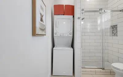 a white refrigerator in a bathroom next to a toilet at The Sea Goddess by Oversee 30A in Santa Rosa Beach