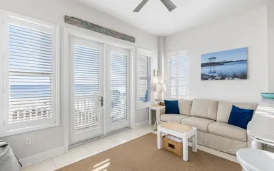 a living room with a couch and windows at The Sea Goddess by Oversee 30A in Santa Rosa Beach