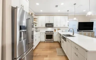 a kitchen with white cabinets and a stainless steel refrigerator at Casa De La Sirena by Oversee 30A in Seacrest